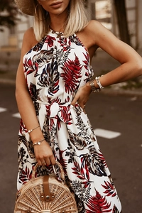 Detail of floral halter neck dress featuring tropical leaf print and waist tie design