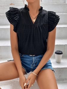 Detail of black V-neck top with ruffled cap sleeves and textured seersucker fabric texture