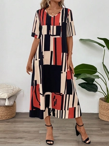 Detail of V-neck printed summer dress with red and black geometric pattern on fabric