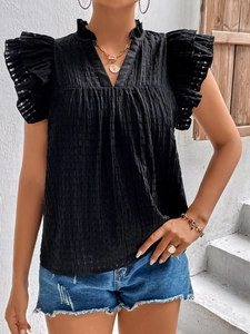 Close-up of black V-neck top with ruffled sleeves and textured checkered fabric finish