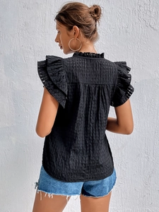 Detail of black V-neck top showing ruffled sleeves and seersucker textured fabric on back