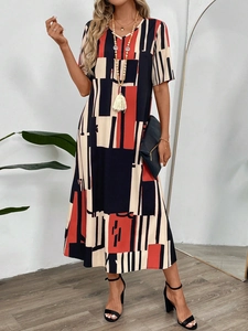 Detail of V-neck summer dress with orange and black geometric print in a lifestyle setting