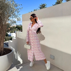 Floral print V-neck maxi dress with long sleeves and buttons shown in a stylish street setting