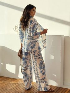 Detail view of tropical floral print on a two-piece leisure shirt and wide-leg pants set