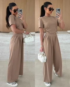 Detail eines khakifarbenen Freizeit-Sets mit Kordelzug am Oberteil und weiter Hose mit Bund