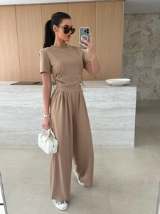 Detail eines minimalistischen erdfarbenen Zweiteilers mit Kordelzug-Top und weiter Hose