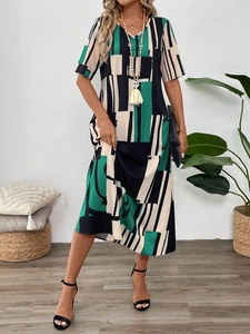 Close-up of V-neck summer maxi dress with abstract geometric print and tassel necklace