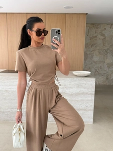 Detail von hellbraunem Crop-Top mit Kordelzug und hoch taillierter Hose mit weitem Bein