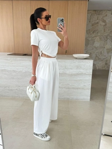 Detail eines weißen Freizeit-Sets mit Kordelzug-Oberteil und weit geschnittener High-Waist-Hose