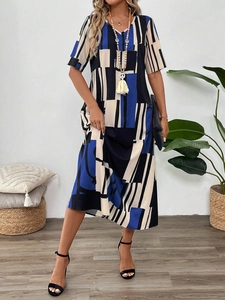 Detail of V-neck printed dress with geometric patterns and beaded tassel necklace