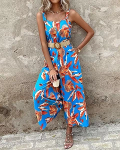 Detail des tropischen Blattdrucks auf blauem Sommer-Jumpsuit mit Webgürtel