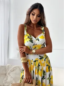 Close-up of summer white dress featuring vibrant yellow lemon prints and wide shoulder straps