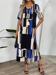 Full shot of a geometric color-block V-neck maxi dress with boho accessories in home setting