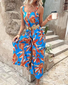 Detail eines blauen Jumpsuits mit Tropenmuster, Strohgürtel und weitem Bein für Sommer