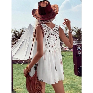 Detail of bohemian white sleeveless top showing back crochet hollow design and feather print