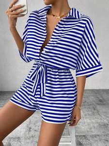Detail of blue and white striped shirt with buttons and adjustable waist tie belt