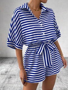 Detail view of the blue striped summer romper featuring a button-up collar and waist tie