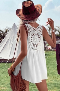 Detail of bohemian white summer vest featuring intricate crochet lace back design