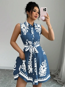 Détail d'une robe fleurie sans manches bleu marine avec boutons et ceinture à la taille