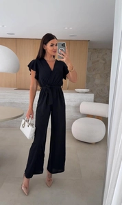 Detail of black V-neck jumpsuit featuring ruffle sleeves and a cinched tie waist design