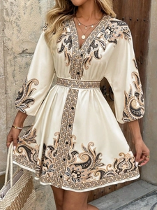 Close-up of elegant ivory paisley print satin dress with V-neckline and lantern sleeves