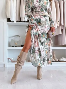Detail of floral pleated maxi skirt with side slit and woven belt on waistline
