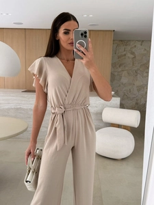 Detail of beige V-neck jumpsuit featuring ruffle sleeves and a drawstring waist tie