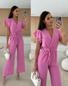Detailed view of women's bright pink V-neck jumpsuit with ruffled sleeves and belted waistline