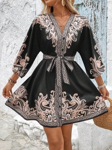 Close-up of bohemian floral print on V-neck dress with button details and waist tie