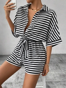 Detailed view of the black and white striped romper with button-down collar and waist tie