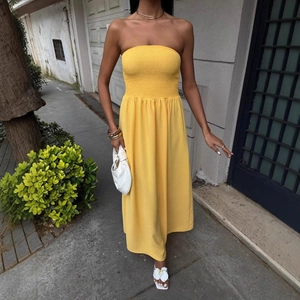 Bright yellow smocked tube midi dress with a flowing A-line silhouette for summer wear
