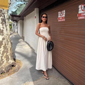 Smocked white strapless maxi dress with A-line skirt and minimalist summer street style