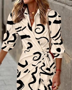 Détail de robe portefeuille imprimée avec nœud à la taille et motifs abstraits noirs