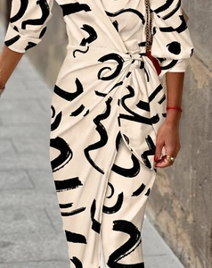 Détail de la taille nouée sur une robe crème à imprimé abstrait et décolleté en V