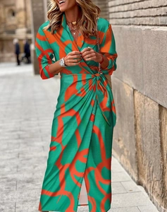 Détail de la robe portefeuille verte avec imprimé abstrait orange et lien à nouer