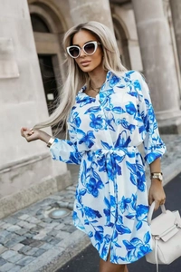 Detail of white floral shirt dress showing blue flower print and adjustable waist tie