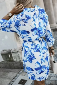 Back view of a long-sleeved floral print shirt dress with tie-waist in a street setting