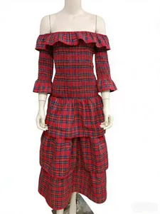 Détail de robe à carreaux rouges avec smocks élastiques et décolleté à volants dénudé