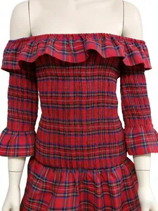 Détail d'un haut à carreaux rouges et bleus avec smocks et volants élégants