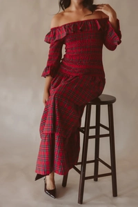 Détail d'une robe à carreaux rouge avec smocks élastiques et volants sur l'épaule