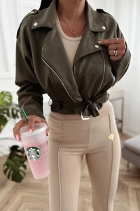 Detail of army green biker jacket featuring lapels, epaulettes and adjustable waist belt