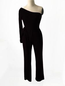Detail of black one-shoulder long sleeve jumpsuit with waist belt and ribbed knit texture