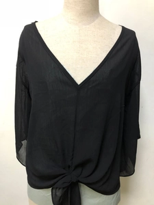 Detail of V-neck sheer chiffon blouse featuring elegant front knot tie and pleated texture