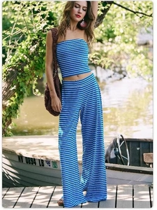 Detail of blue and white striped tube top and high-waist wide-leg pants on a wooden boat