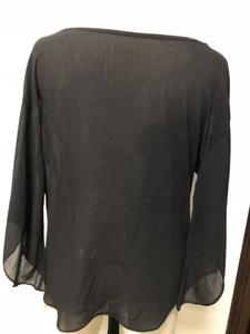 Detail shot of sheer black chiffon fabric on a loose V-neck blouse with tiered flare sleeves