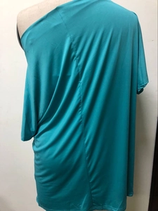 Detail of turquoise off-shoulder top with batwing sleeves and vertical back seam detail