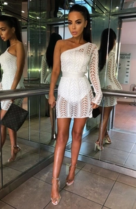 Détail de la robe en maille blanche montrant la texture florale ajourée et la coupe ajustée