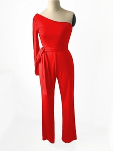Detail of red one-shoulder jumpsuit featuring a tied waist belt and long sleeve design