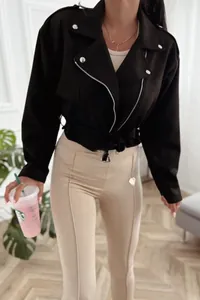 Detail view of a black faux suede moto jacket featuring silver zippers and a waist belt