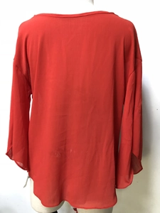 Detail view of the back of a red chiffon V-neck blouse on a mannequin stand